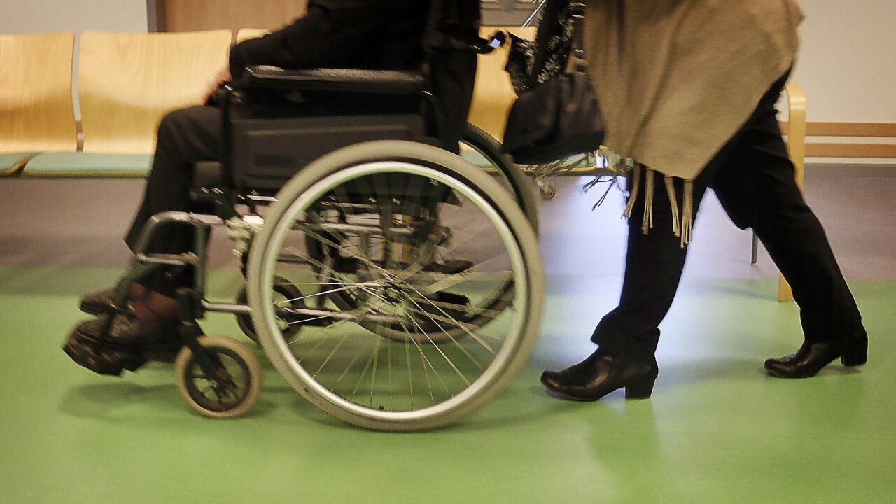 Iemand in een rolstoel wordt voortgeduwd, je ziet alleen de benen en voeten. Foto: Peter Schoonen voor Meer over Medisch.